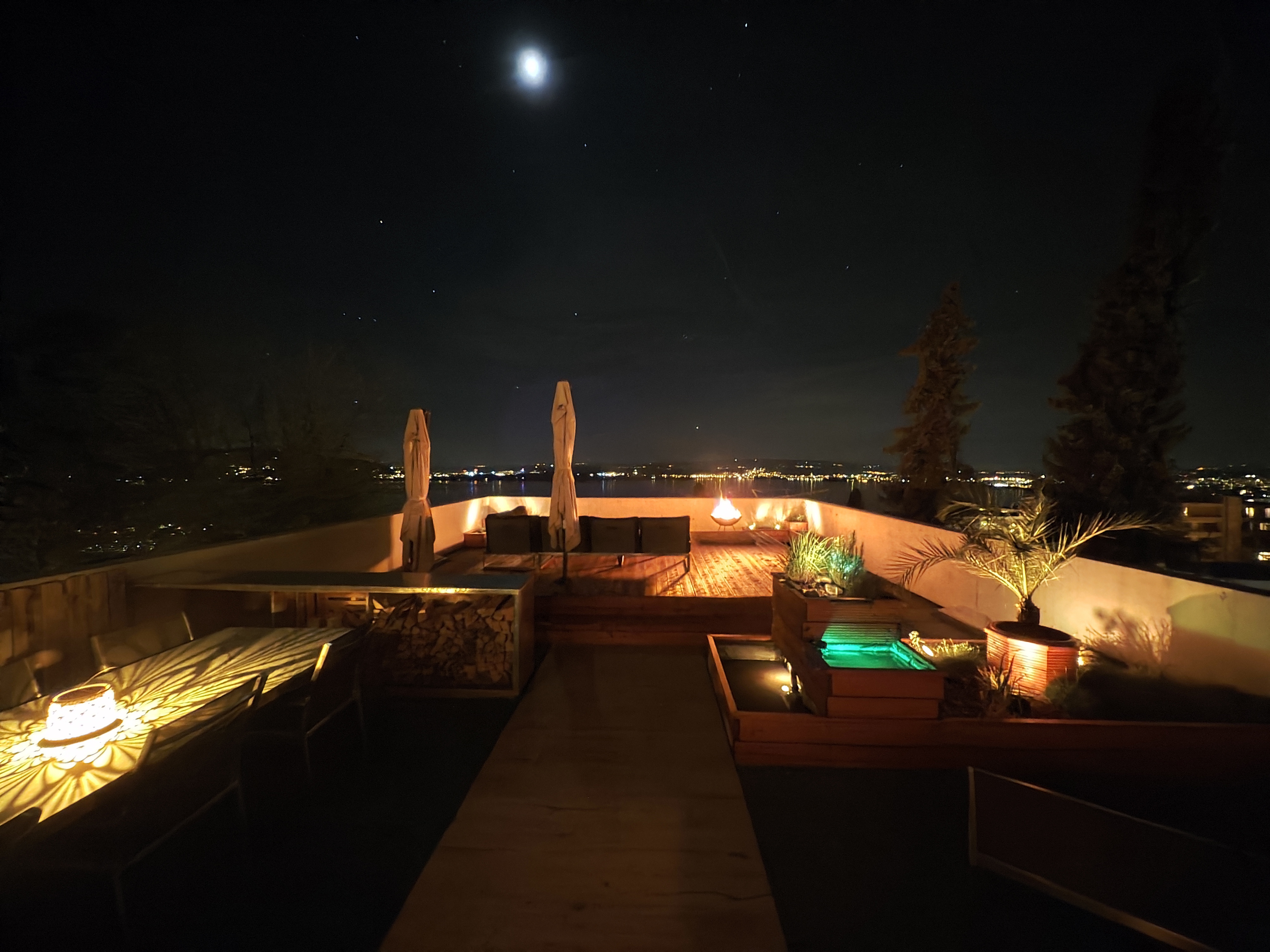 Beleuchtete Terrasse bei Nacht mit warmen Lichtlinien und Gartenpflanzen