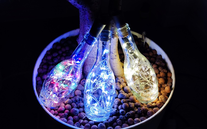 Leuchtende Flaschenlichter mit Korken und dekorativen Steinen