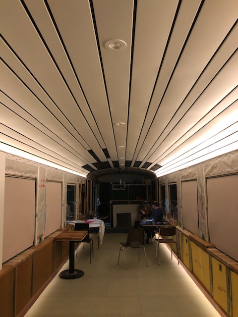 Langer Restaurant/Ausstellungsrau mit LED-Linien entlang der Decke und der Vitrinen